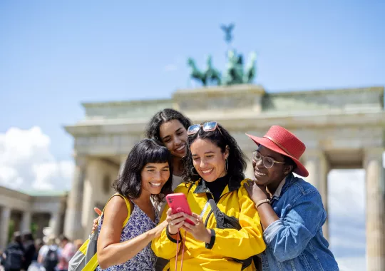 Multiracial group of women friends on vacation looking at their pictures on a smart phone Multiracial group of women friends on vacation looking at their pictures on a smart phone